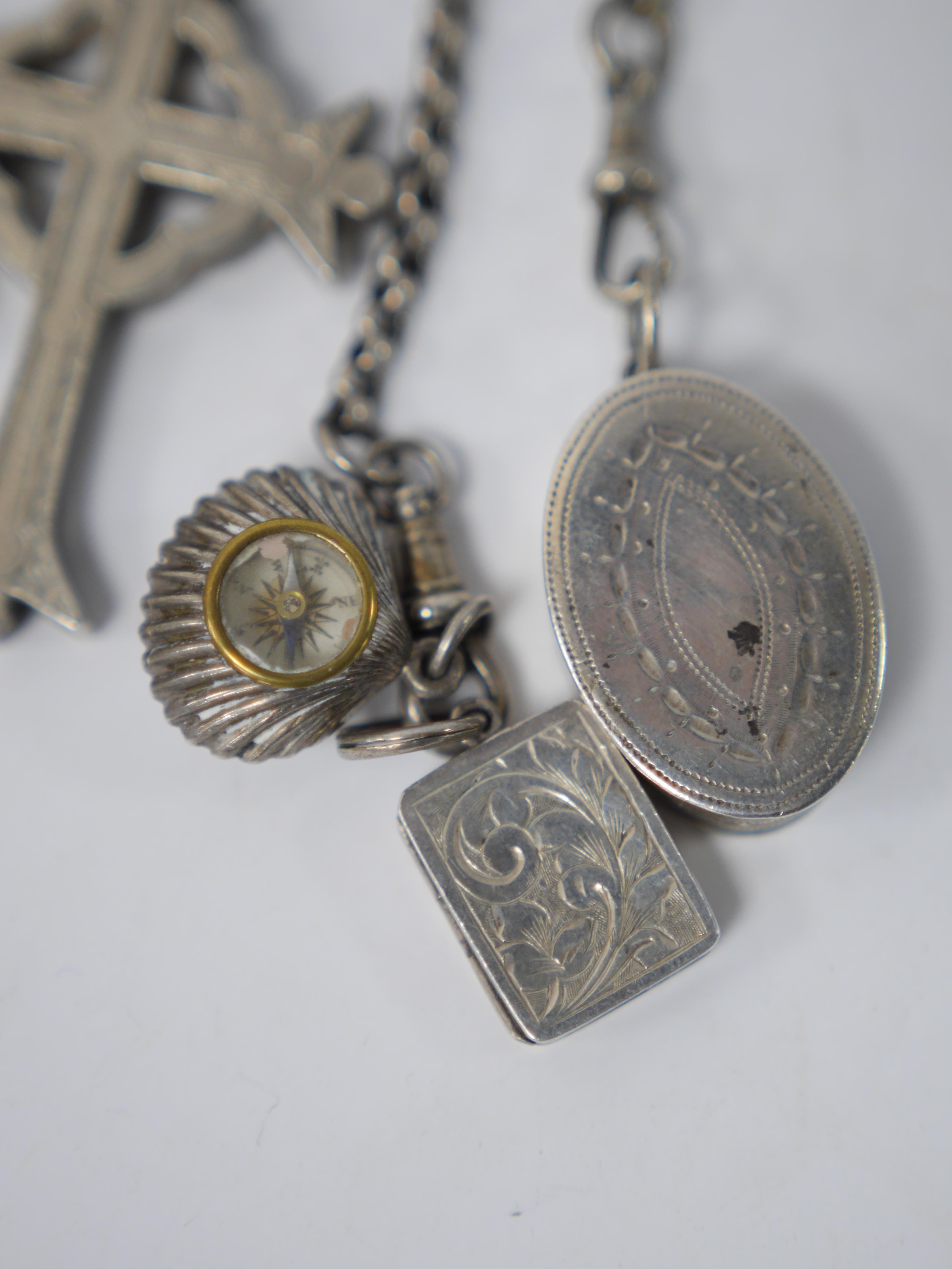 A late 19th/early 20th century continental white metal chatelaine, hung with six assorted accoutrements including a small silver box, a George III silver oval snuff box, a pen knife, compass and cross pendant. overall ap